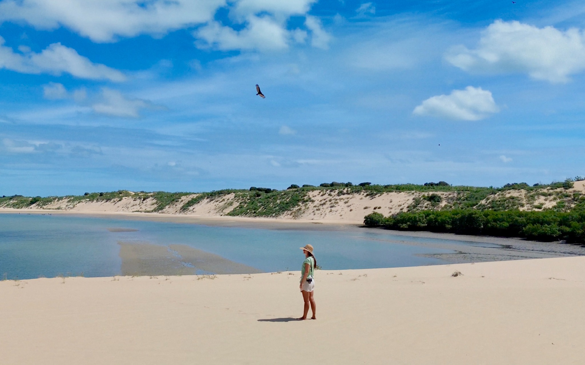 Uma faixa de areia entre dunas e águas tranquilas