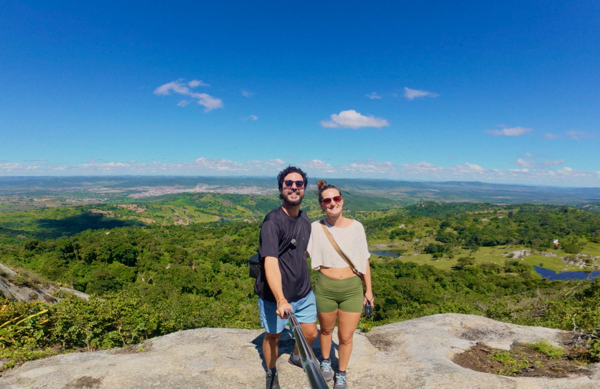 Uma vista ampla do casal no alto de um mirante